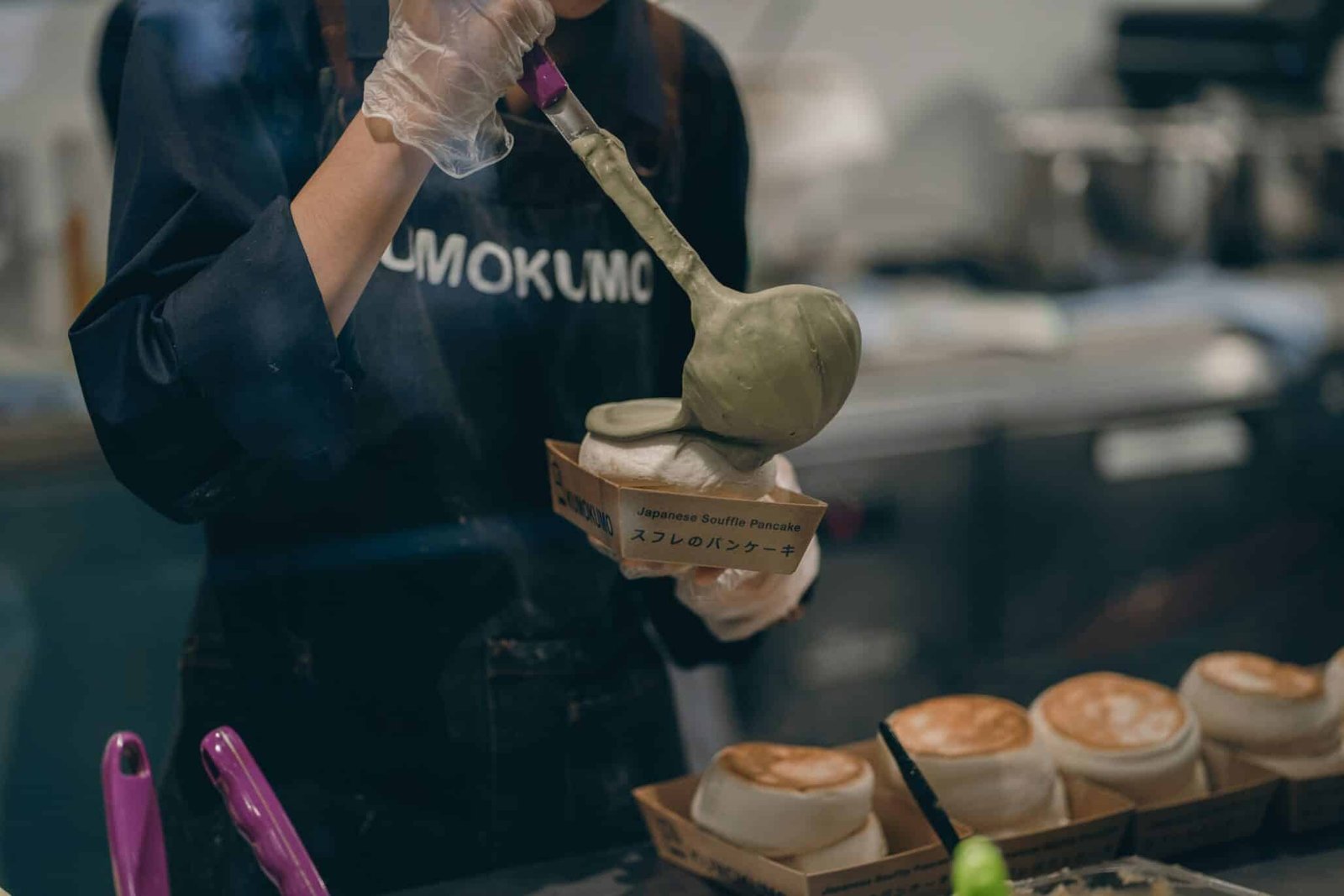 a woman in a kitchen preparing food with a spoon scaled